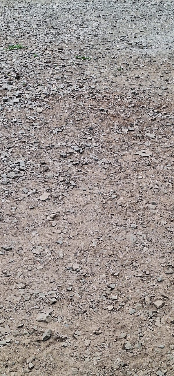 Gravel ground and a parked red cargo tricycle in Nakhodka