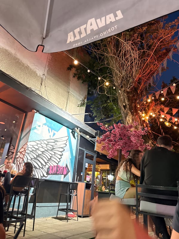 Lovech café night: string lights, Lavazza branding, and a bold mural