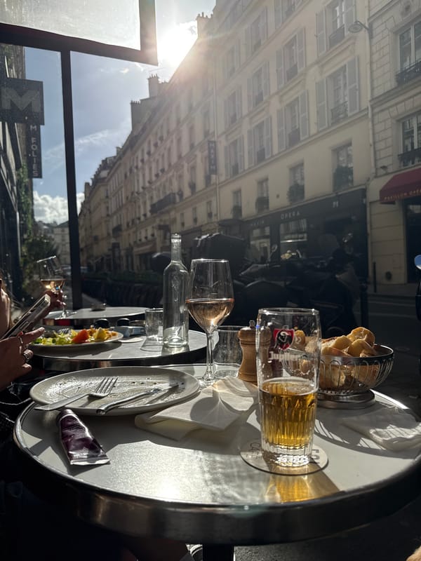 Golden retriever rests near Parisian street cafe during sunny afternoon