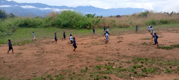 Children play informal soccer game in rural Congo village