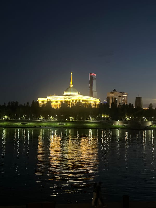 Astana at night: Bayterek monument and waterfront reflections