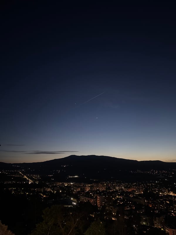 City lights illuminate mountain valley at dusk