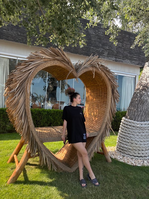 Woman poses with heart-shaped chair in Varna garden