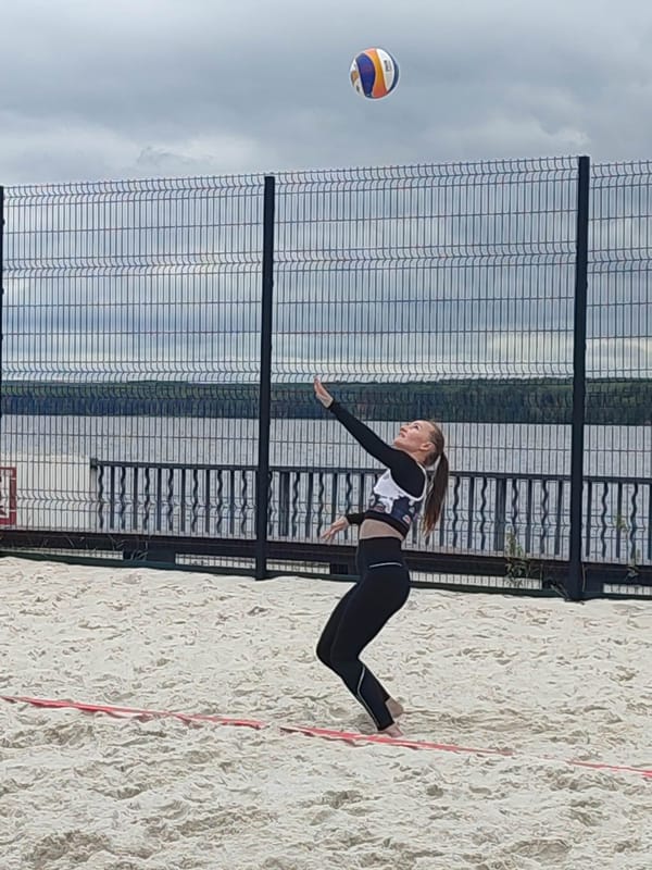Beach volleyball match in progress on a cloudy day