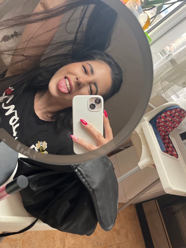 Woman applies makeup in mirror selfie in Pernik, Bulgaria