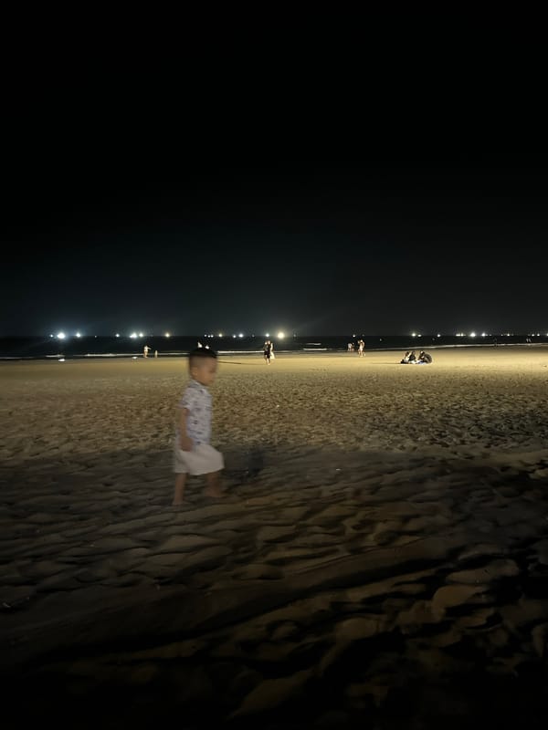 Child plays on Đà Nẵng beach during evening hours