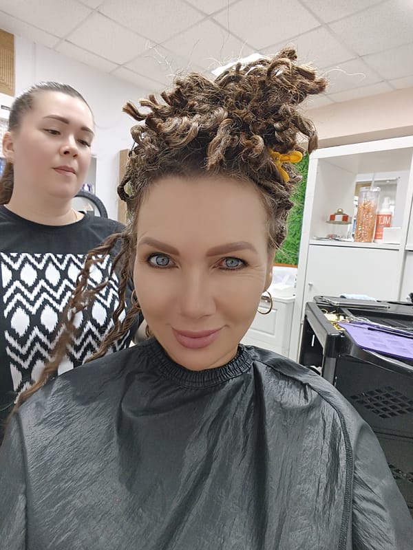Dreadlock styling session at a Chaikovsky salon, baby in tow