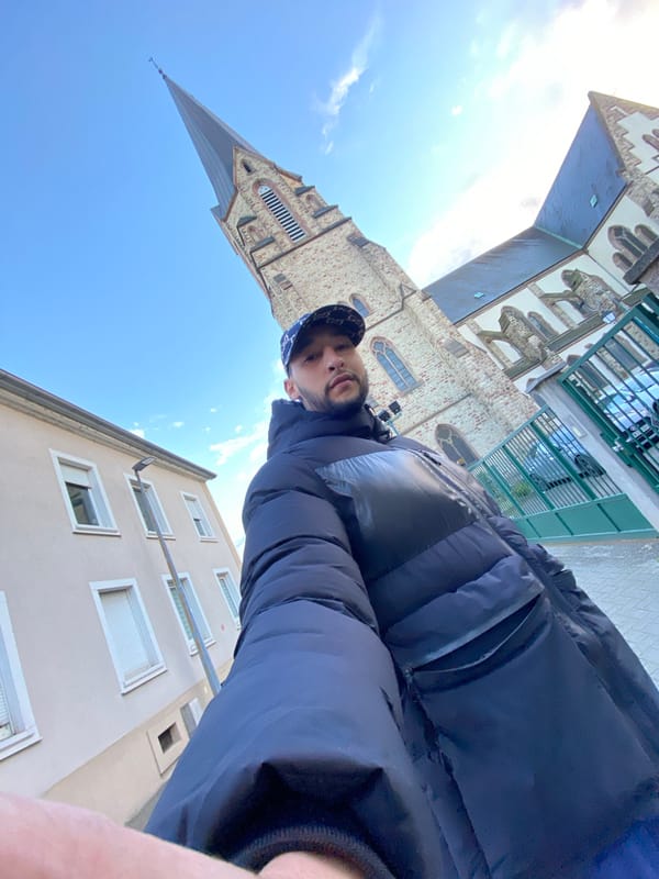 Person photographed walking through Bischheim streets near historic church