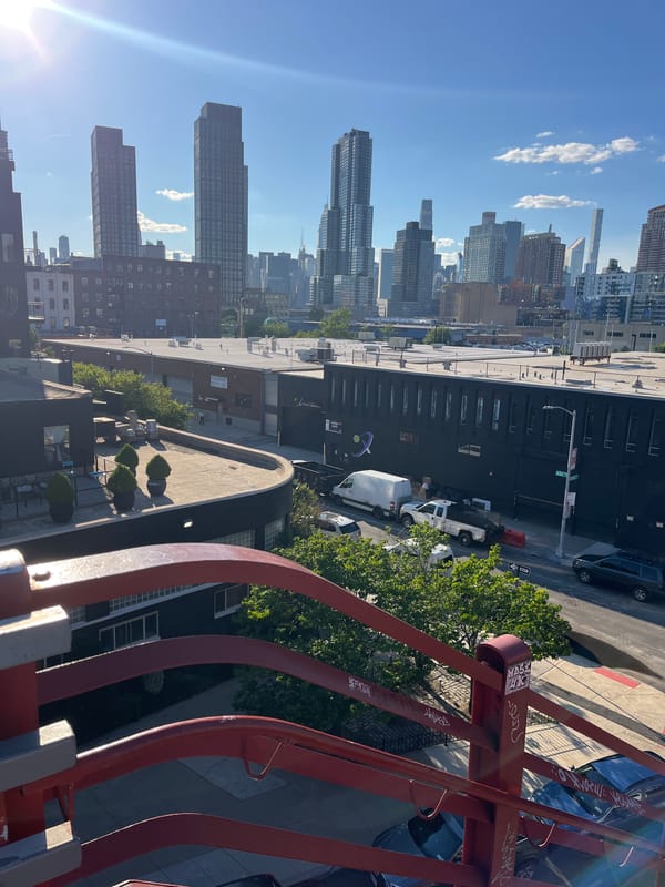 Cyclists gather on a NYC drawbridge with skyline views