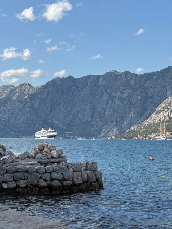Kayaks and stone walls along the Bay of Kotor in Prčanj