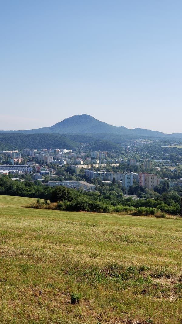 Abstract crucifixion sculpture overlooks Prešov from a hilltop meadow