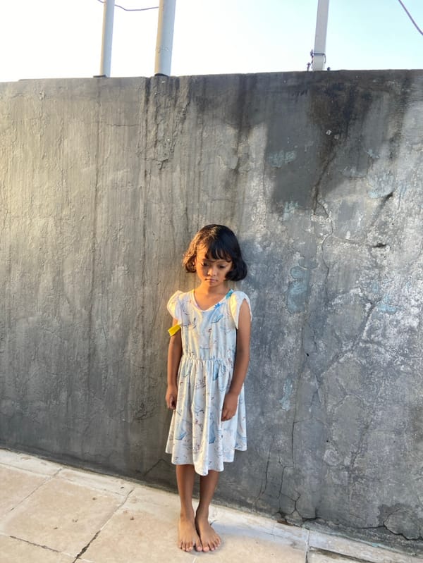Young girl plays with toys in Indonesian neighborhood