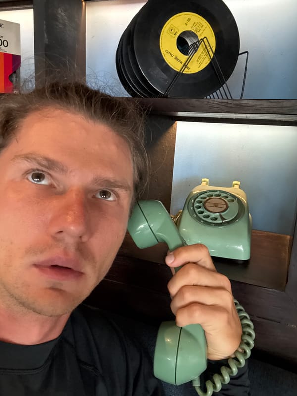 Person photographed with vintage rotary phone in Kuta