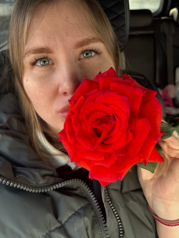 Woman takes selfies with red rose in Perm vehicle