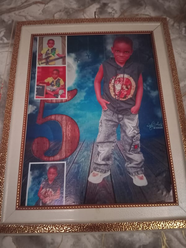 Boy builds cardboard model in decorated room, Shagamu Nigeria