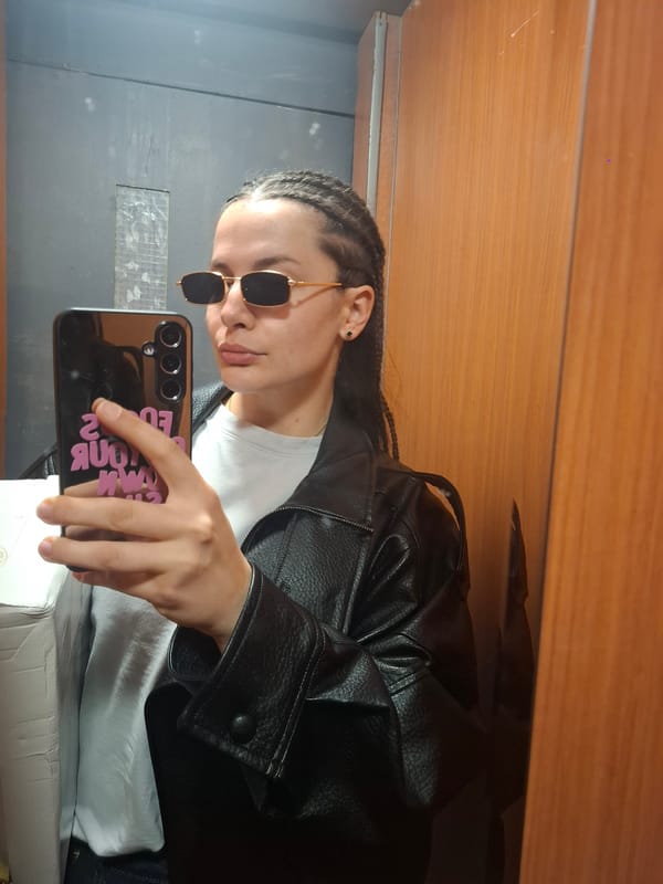 Person in leather jacket takes mirror selfie