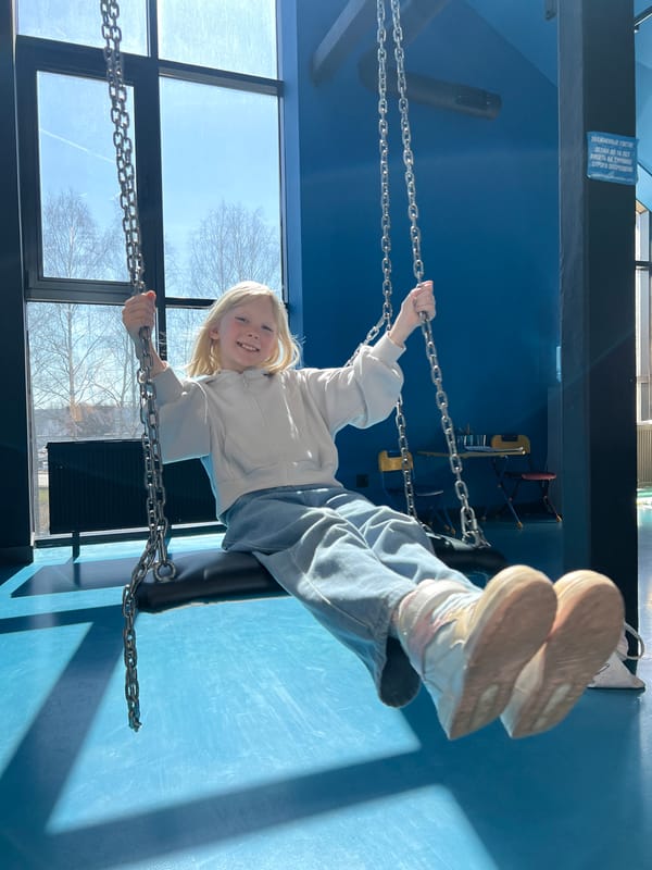 Child plays on indoor swing in Izhevsk building