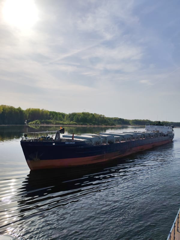 Cargo barge navigates Russian river carrying containerized freight