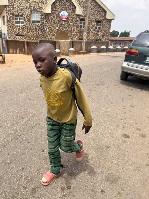 Young boy with backpack observed on street in Jos