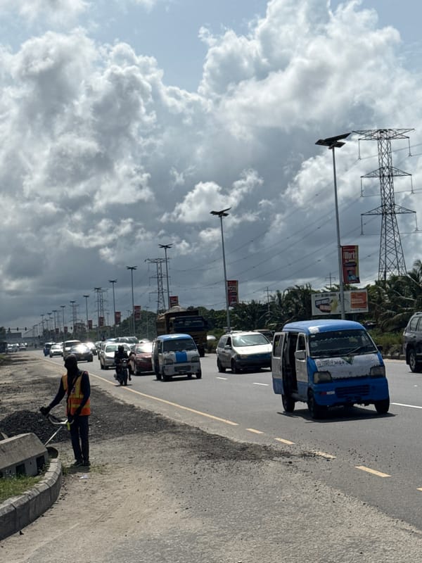 Street vendor walks along overcast Lekki road