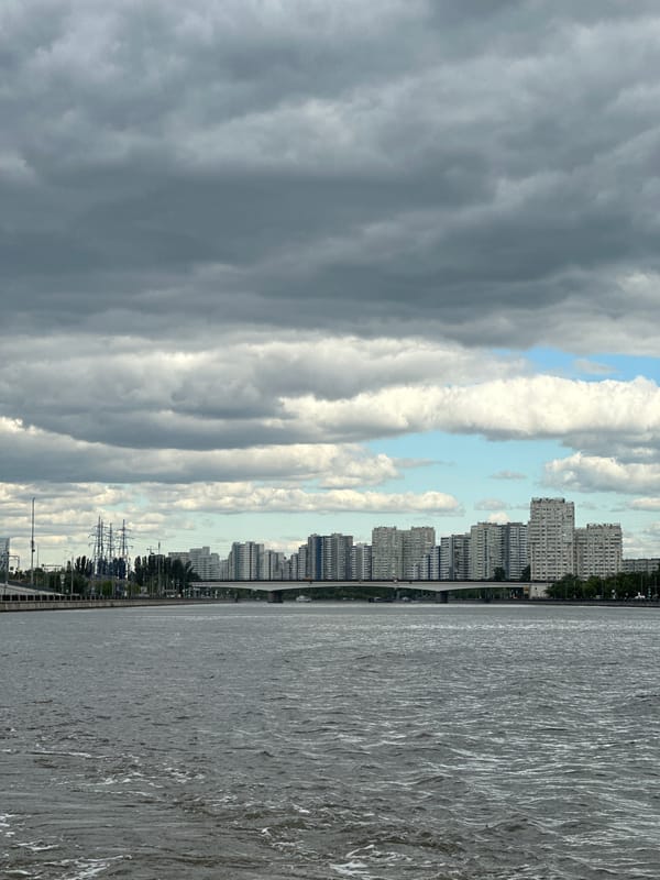 Modern riverboat navigates a grey Moscow River under patchy skies