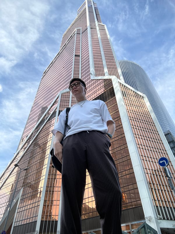 Posed outside a rose-gold glass tower in Khimki