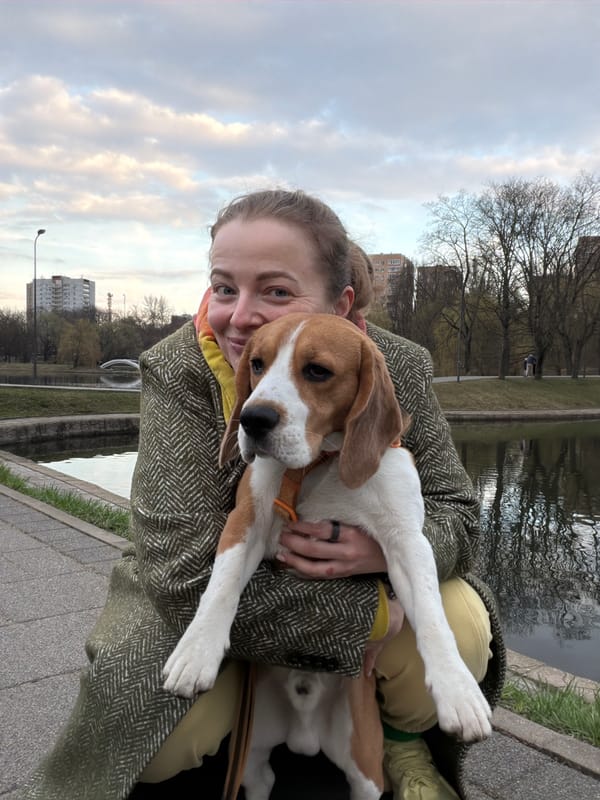 Woman holds beagle near Moscow waterway