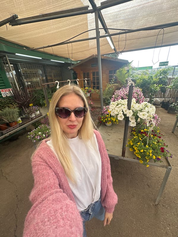 Woman visits flower market in Petah Tikva, poses among colorful blooms