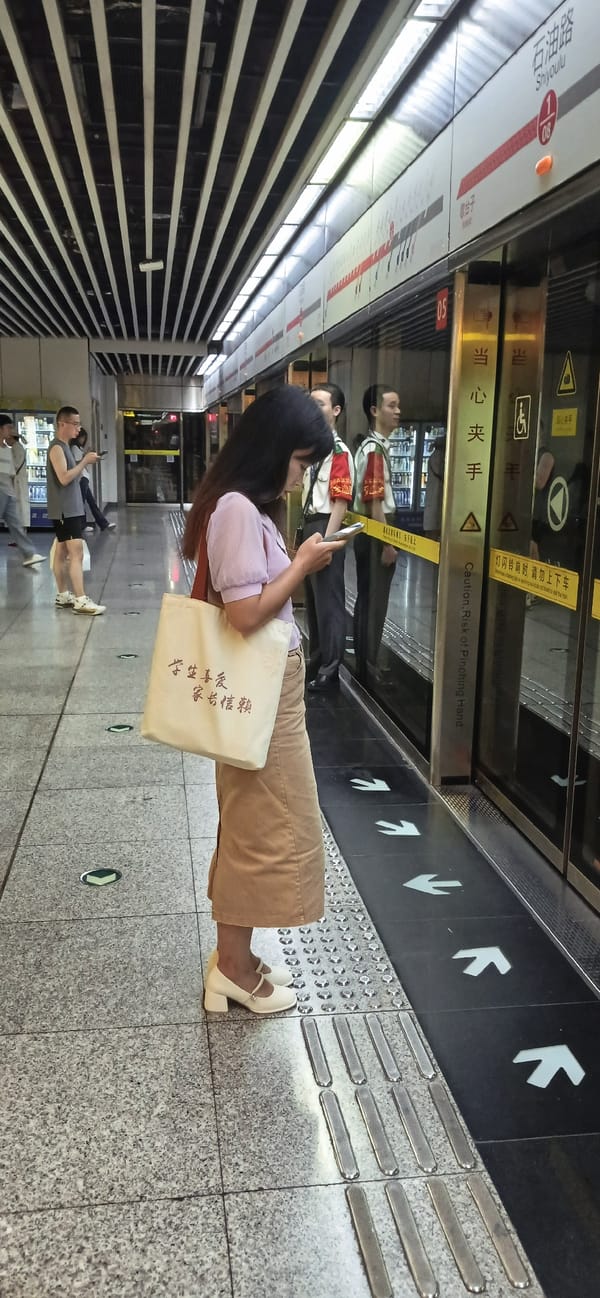 Woman uses phone during morning commute at Chongqing subway station