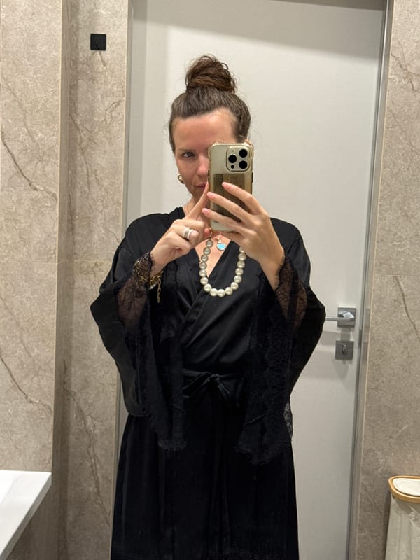 Bathroom mirror selfie in black robe and pearl necklace