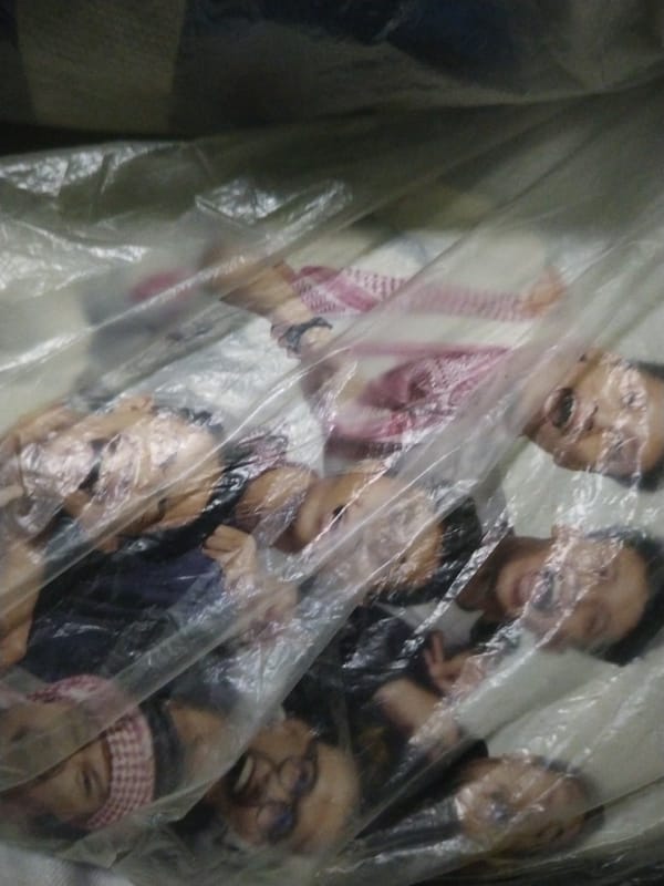 People lying under clear plastic sheet on indoor mat