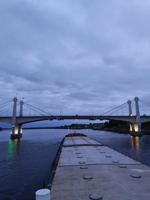 Barge approaches bridge in Kimry, Russia under overcast skies