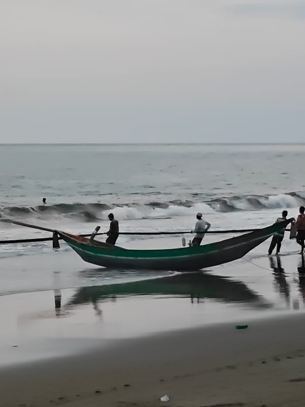 Net hauling and fishing boats on an Indonesian beach at dusk