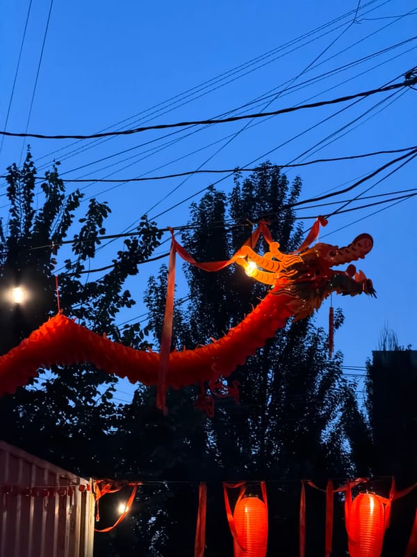 Red lanterns and a dragon float illuminate Bishkek at dusk