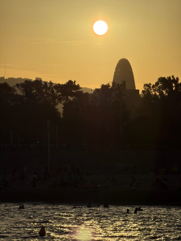 Golden hour over Barcelona's waterfront, crescent moon rising