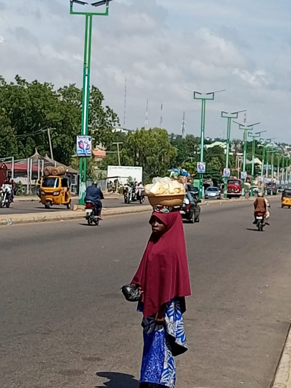 Balancing a food basket while walking an urban roadside