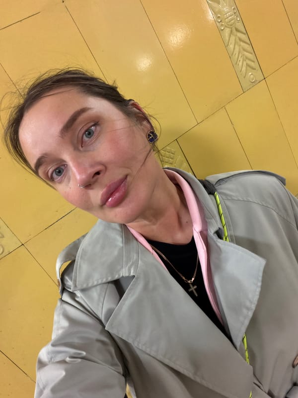 Woman in gray coat observed on Moscow tiled floor