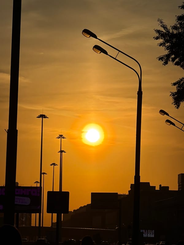 Urban sunset documented with silhouetted streetlights visible