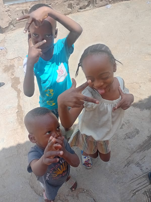Children play during community washing activities in sunny courtyard