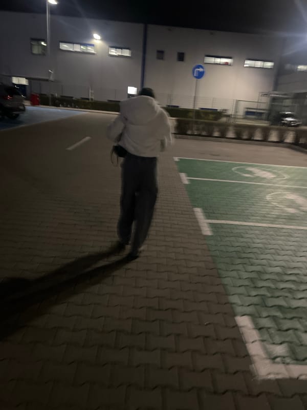 Person in hoodie walks quickly past building in Bulgaria