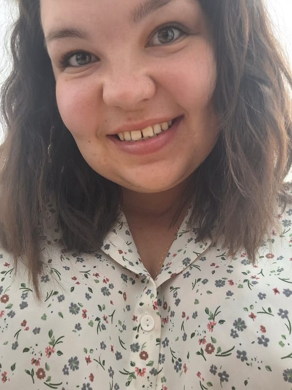 Woman in floral blouse photographed smiling in Markovskii