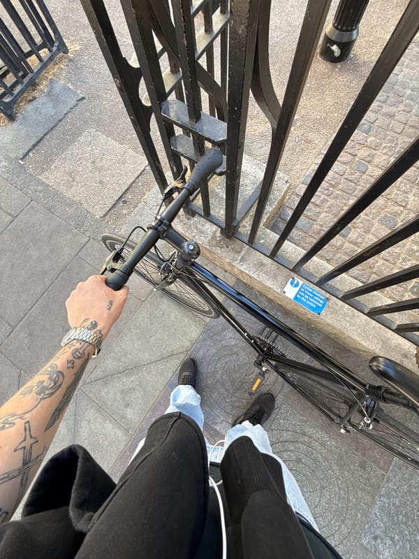 Cyclist pauses with bicycle on London street