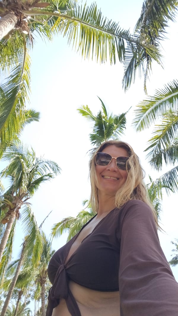 Woman poses among palm trees in Jiyang District