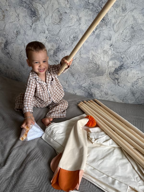 Child plays with wooden materials beside teepee tent in Russia