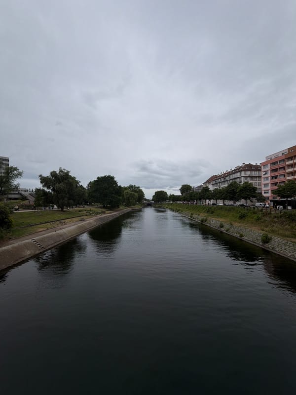 Cyclist spotted along Strasbourg waterway during overcast afternoon