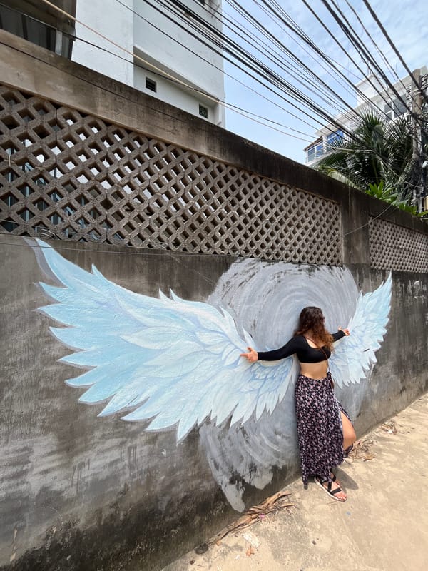 Posing with murals along the walls of Mũi Né