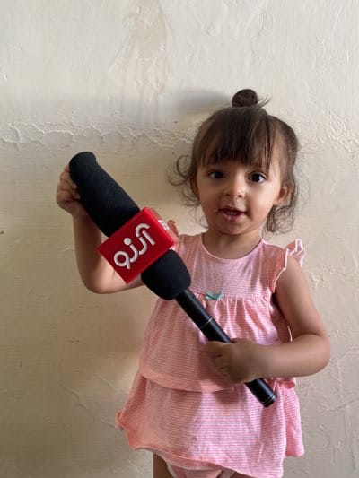Toddler plays with toy microphone in Kandahar home