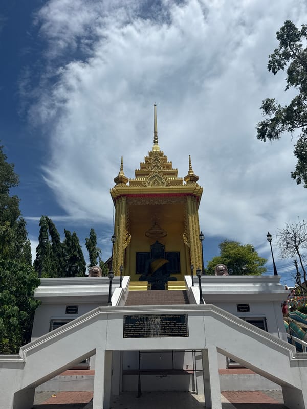 Golden temple with dark statue photographed in Baan Mae Nam