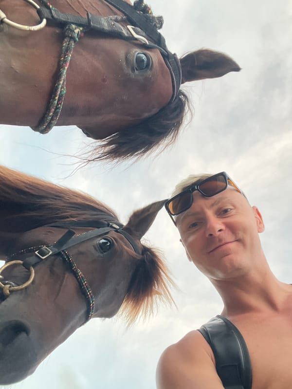 Tourist documents beach day with horses in Jimbaran, Indonesia