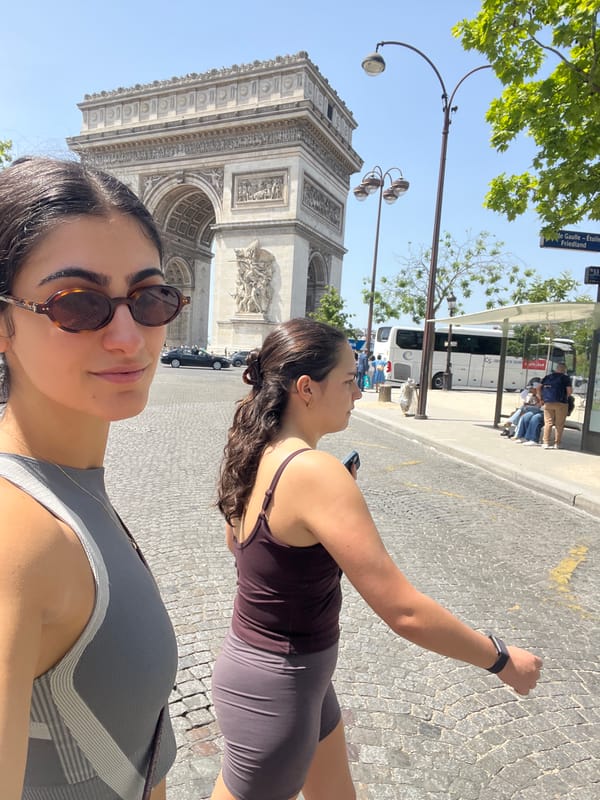 Tourists pose for photos at Arc de Triomphe